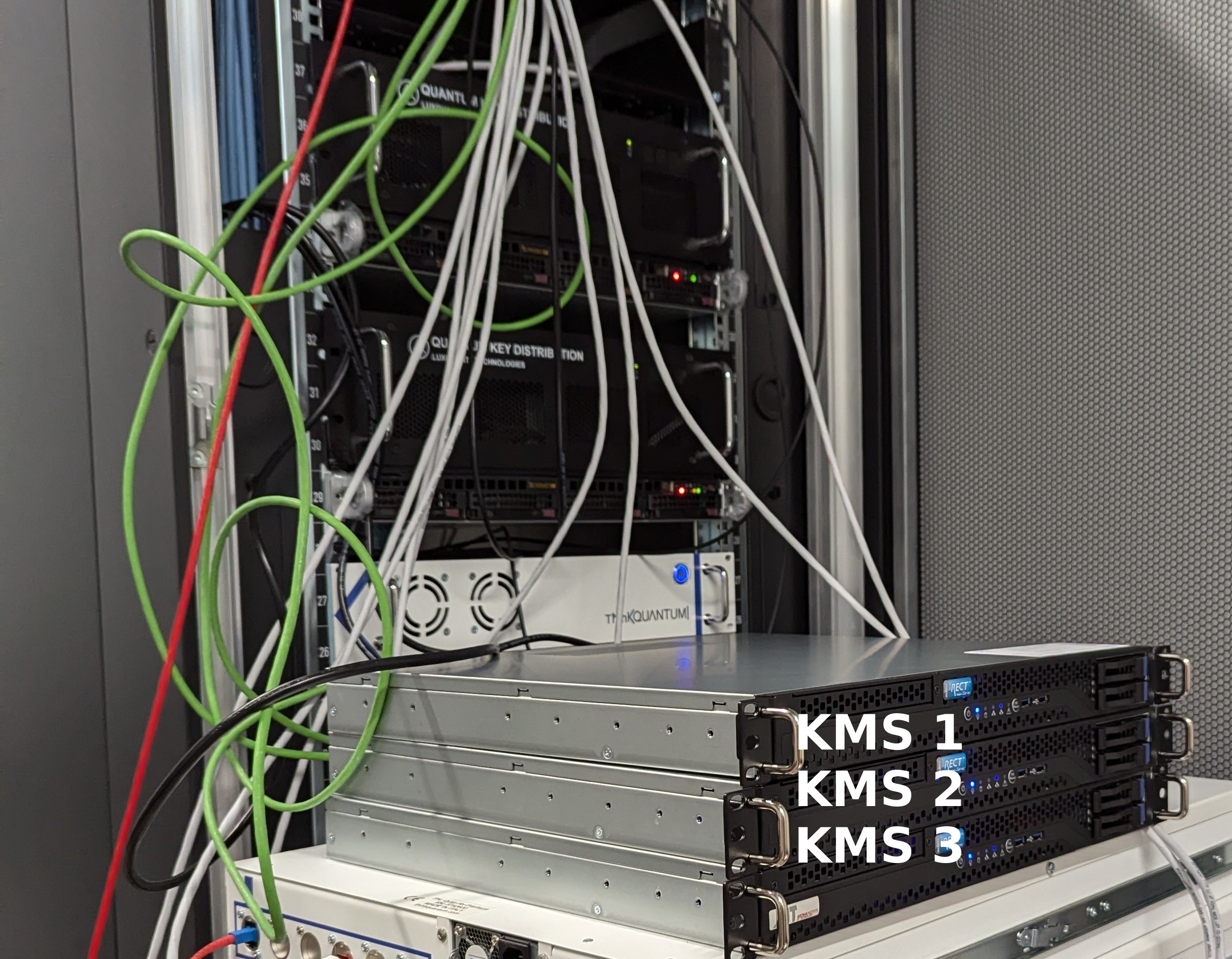 three AIT-KMS servers within the laboratory. In the background QKD devices by different manufacturers can be seen, that are within the same test network.